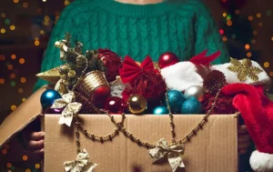 A person holding a box full of holiday decorations