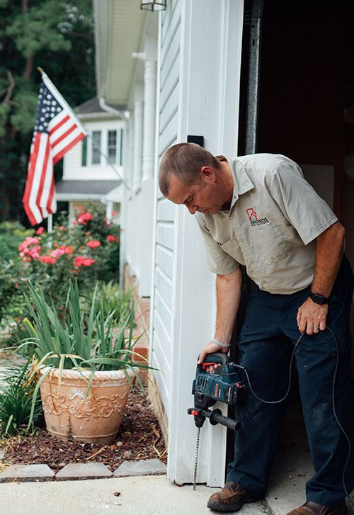 Owner of Innovative Pest Solutions, Kevin Spillman, drilling termite holes