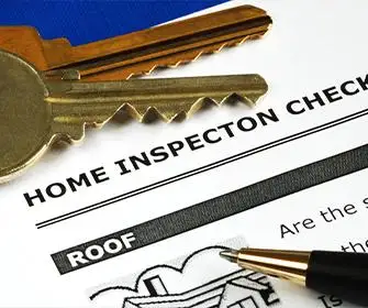 Close-up shot of a home inspection check with a pen and keys