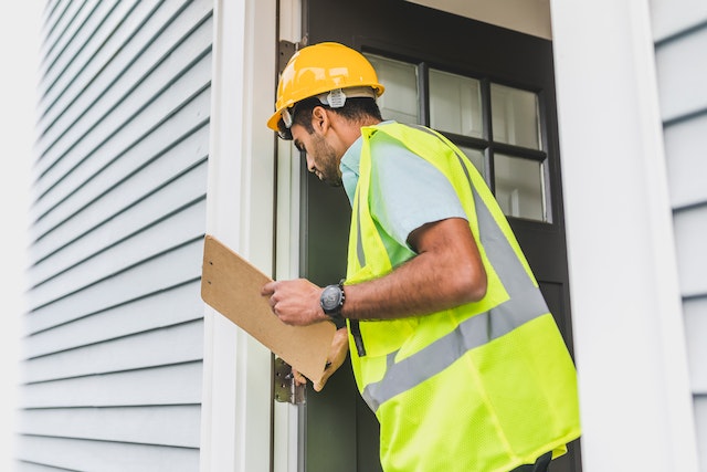 Home inspector looking at a door frame, displaying how to check for termites in wooden structures