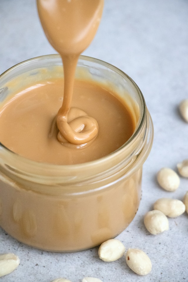 Peanut butter, bait for mouse traps, being put into a clear bottle