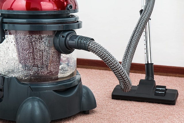 A large steaming vacuum cleaner on carpet, one of the ways to eliminate fleas in your carpet